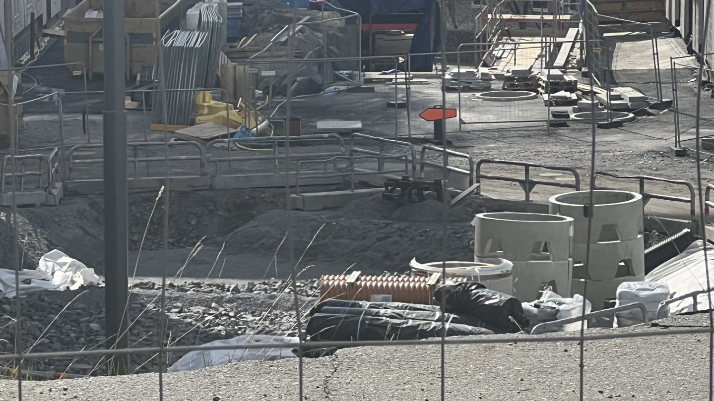Byggarbetsplats i Nacka med grushögar och betongrör, symboliserar byggkaoset.